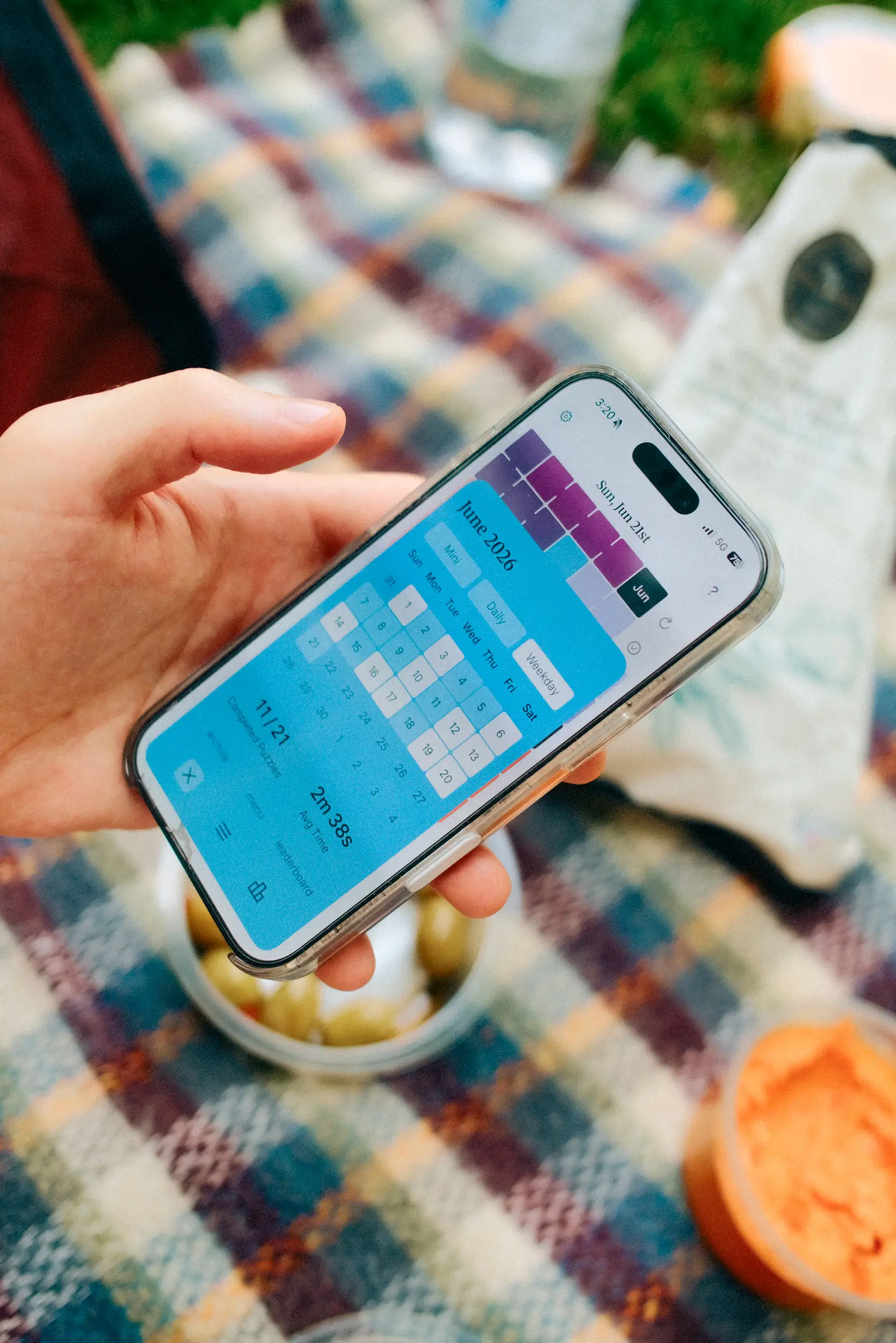 Photo of someone's hand holding up a phone with the calendar puzzle app open, showing the archive page.