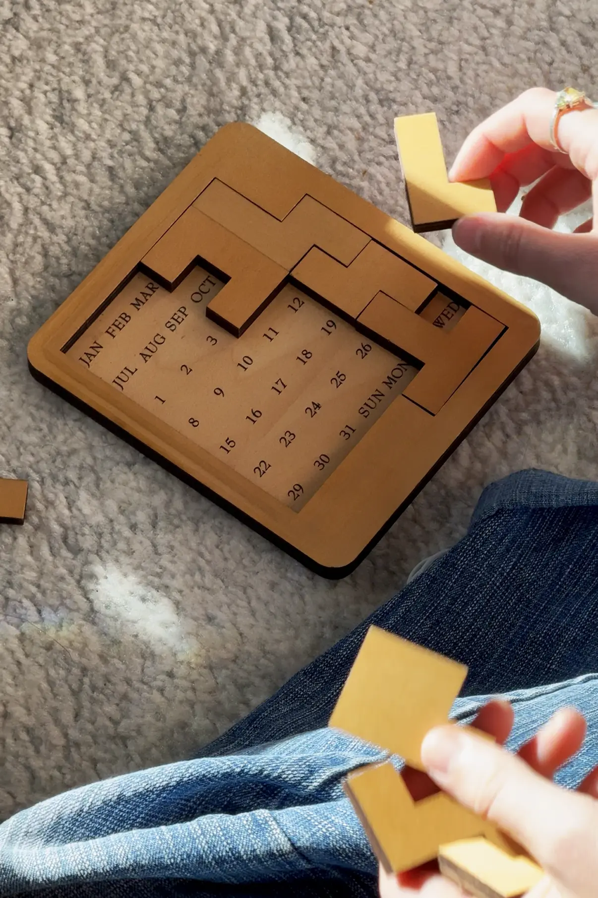close up photo of a person's hands while playing the physical calendar puzzle
